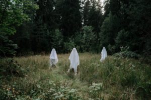 Scary ghosts hanging around in a forest.