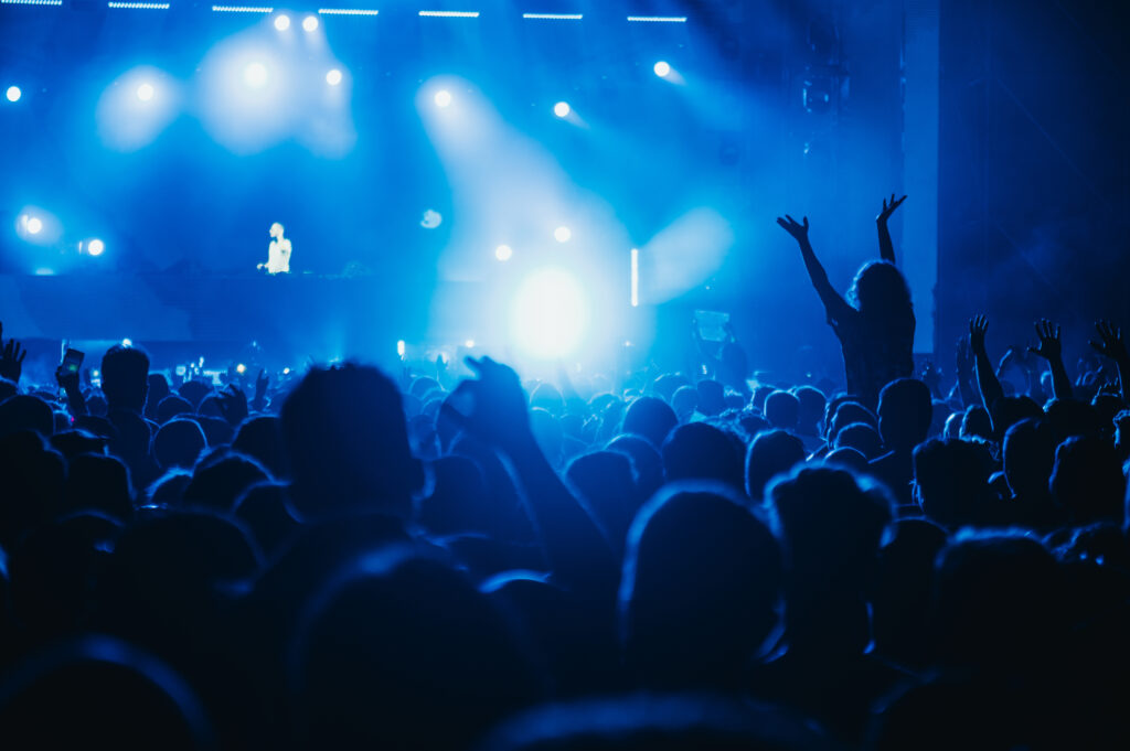 People in a crowd of a music concert having fun while listening their favorite artist. Youth and celebration concept. Music festival concept.